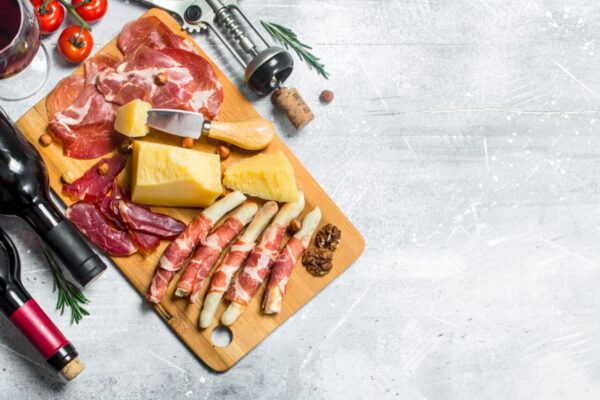 Antipasto background. Various meat and cheese snacks with red wine.