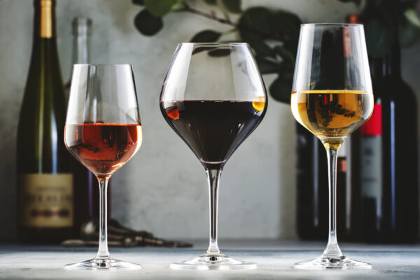 Wines assortment. Red, white, rose wine in wineglasses and bottles on gray background. Wines assortment. Red, white, rose wine in wineglasses and bottles on gray background.